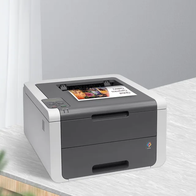 A color laser printer on a white desk with a printed page in the tray